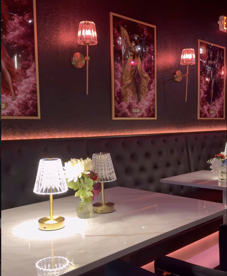 Intimate booth with crystal lamps and celestial artwork at Babe