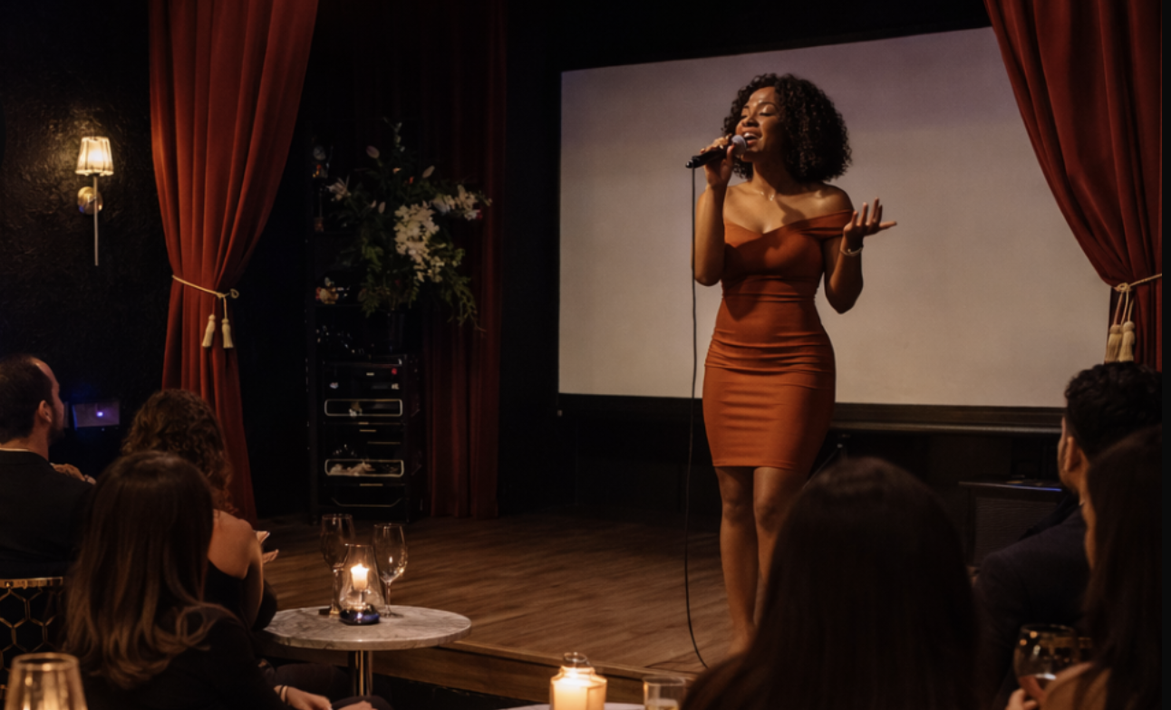 Open mic night performer singing on stage at Babe Coffee Lounge with audience seated at candlelit tables