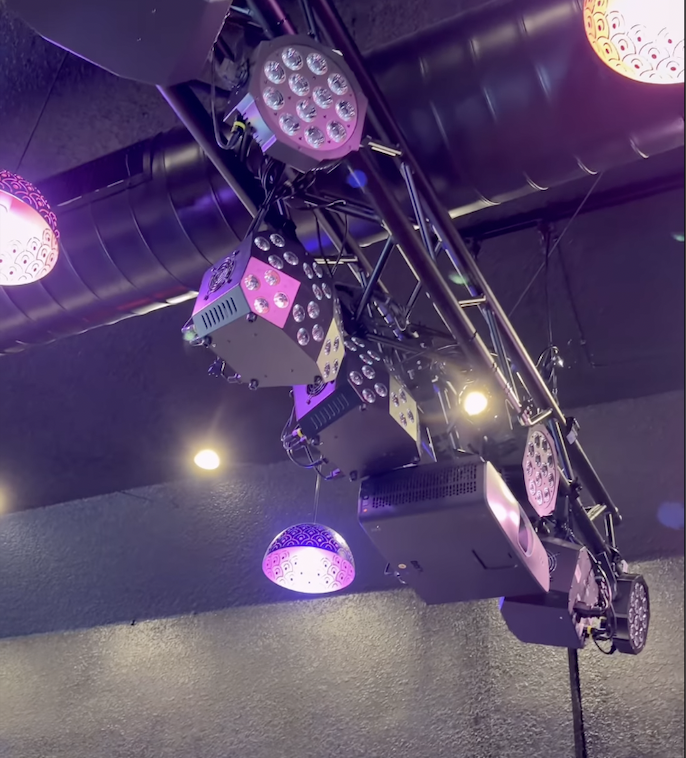 Professional stage lighting rig with LED par cans and purple ambient glow